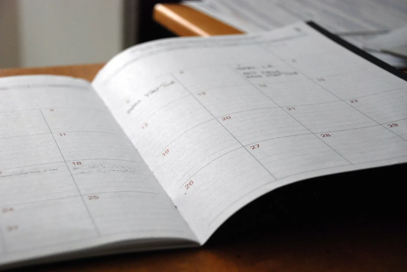 An open monthly planner on a wooden desk