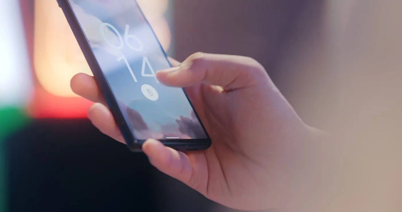 A hand unlocking a smartphone with a fingerprint sensor